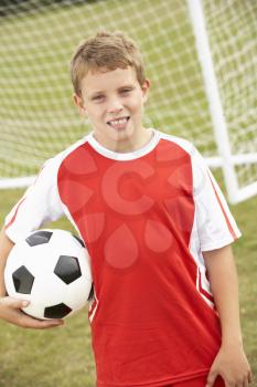 Portrait boy in soccer kit with ball