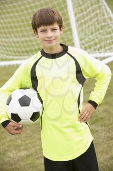 Portrait boy in goalkeeper's kit with ball