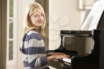 Girl playing grand piano at home