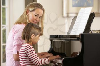 Young girl playing piano in music lesson
