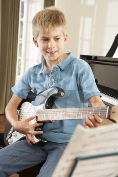 Boy playing electric guitar at home