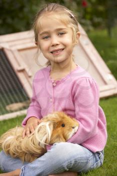 Young girl in garden holding guinea pig