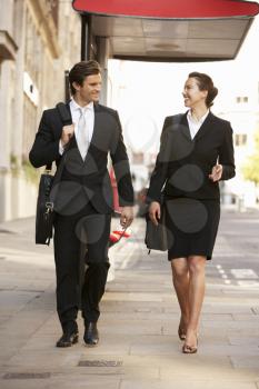 Businessman and businesswoman walking in street
