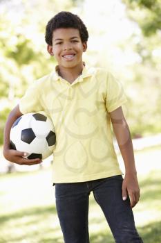 Boy in park holding football