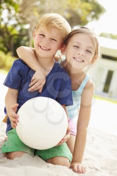 Two Children Playing Game Of Volleyball In Garden
