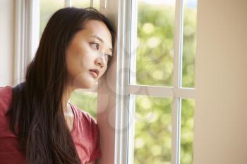Thoughtful Asian Woman Looking Out Of Window