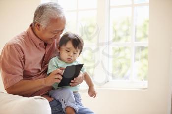 Grandfather And Grandson Using Digital Tablet Together