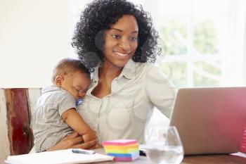 Mother With Baby Working In Office At Home