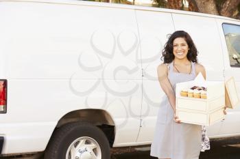 Female Baker Delivering Cakes Standing In Front Of Van
