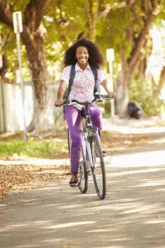 Young Woman Cycling Along Street To Work