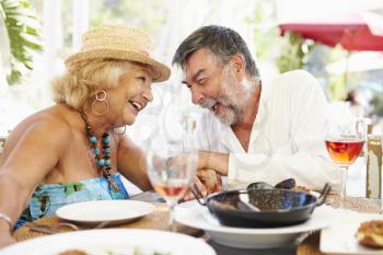 Senior Couple Enjoying Meal In Outdoor Restaurant