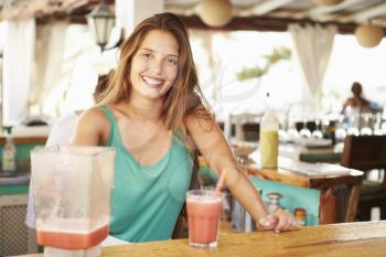 Woman In Restaurant Making Fruit Smoothies