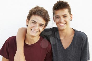 Portrait Of Two Hispanic Teenage Boys Leaning Against Wall