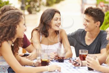 Group Of Teenage Friends Sitting Together At Caf�