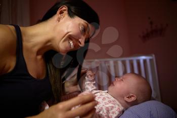 Mother Comforting Crying Baby In Nursery