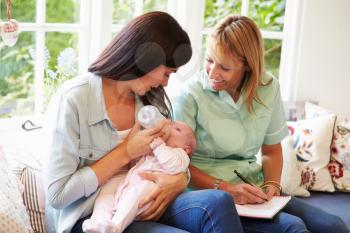 Mother With Baby Meeting With Health Visitor At Home
