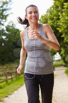 Woman Running In Countryside Wearing Earphones