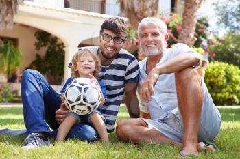 Grandfather Sitting In Garden With Son And Grandson