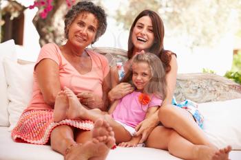 Grandmother,Mother And Granddaughter Sitting Outdoors