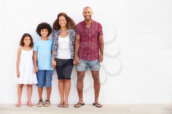 Family Standing Outdoors Against White Wall