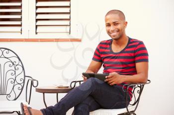 Man Sitting Outdoors With Digital Tablet And Drinking Coffee