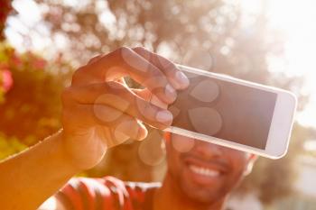 Man On Holiday Taking Selfie With Mobile Phone