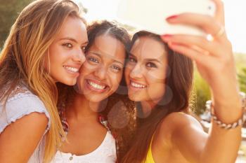 Female Friends On Holiday Taking Selfie With Mobile Phone