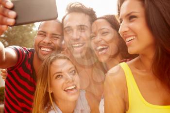 Group Of Friends On Holiday Taking Selfie With Mobile Phone