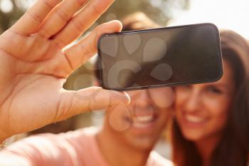 Couple On Holiday Taking Selfie With Mobile Phone