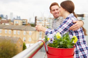 Couple Relaxing Outdoors On Rooftop Garden