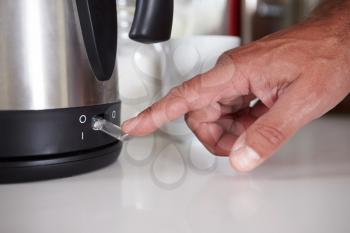 Close Up Of Man Turning On Switch To Boil Kettle
