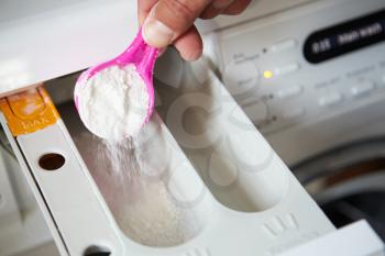 Close Up Of Man Putting Detergent Into Washing Machine