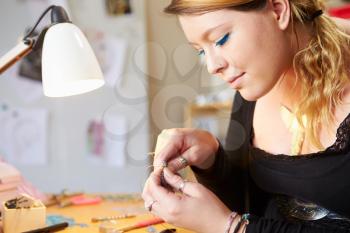 Young Woman Making Jewelry At Home