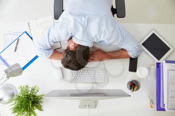 Overhead View Of Tired Businessman Resting By Computer