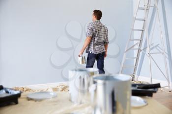 Man Decorating Nursery For New Baby