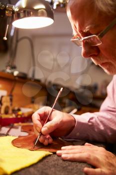 Man Restoring Violin In Workshop