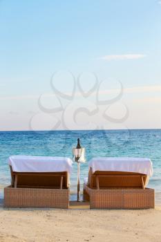 Loungers At Edge Of Tropical Sea With Champagne Bucket