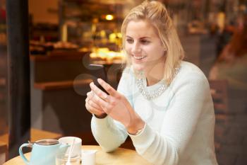 Woman Viewed Through Window Of Caf Using Mobile Phone