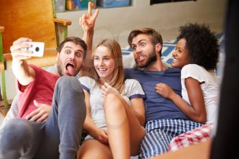 Group Of Friends Wearing Pajamas Taking Selfie On Mobile