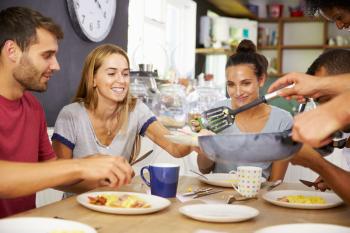 Group Of Friends Enjoying Breakfast In Kitchen Together