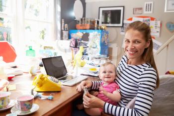 Mother With Daughter Running Small Business From Home Office