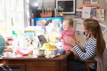 Mother With Daughter Running Small Business From Home Office