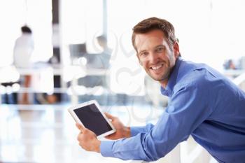 Portrait of man in office using tablet