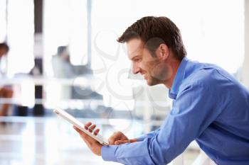 Portrait of man in office using tablet