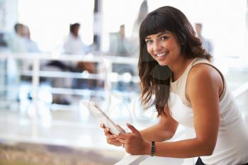 Portrait of smiling woman in office with digital tablet