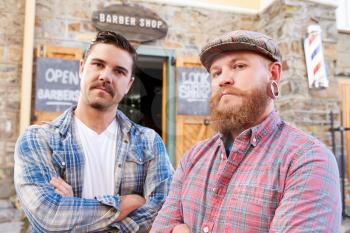 Portrait Of Two Hipster Barbers Standing Outside Shop