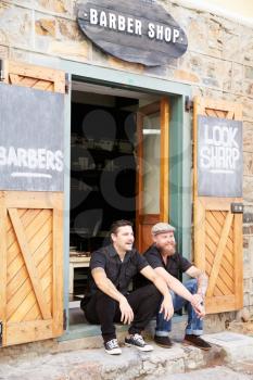 Portrait Of Two Hipster Barbers Standing Outside Shop