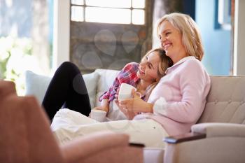 Mature Mother With Adult Daughter Watching TV At Home