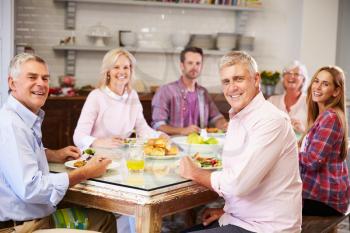 Portrait Of Friends Enjoying Meal At Home Together