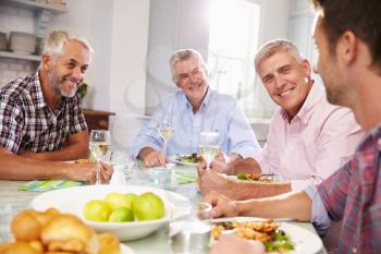 Group Of Mature Male Friends Enjoying Meal At Home